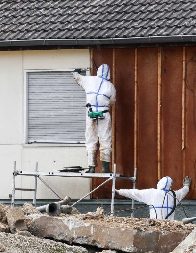 protective suits remove asbestos on a wall-adhdcontracting